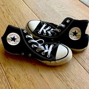 Black hightop Chuck Taylor All Star shoes.